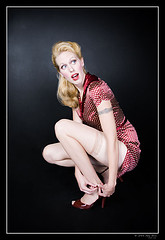 pinup - blonde woman fixing shoe in dress